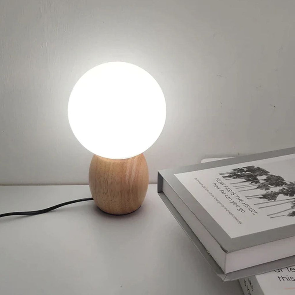 Lampada da tavolo in legno nordico con latte a sfera di vetro bianco