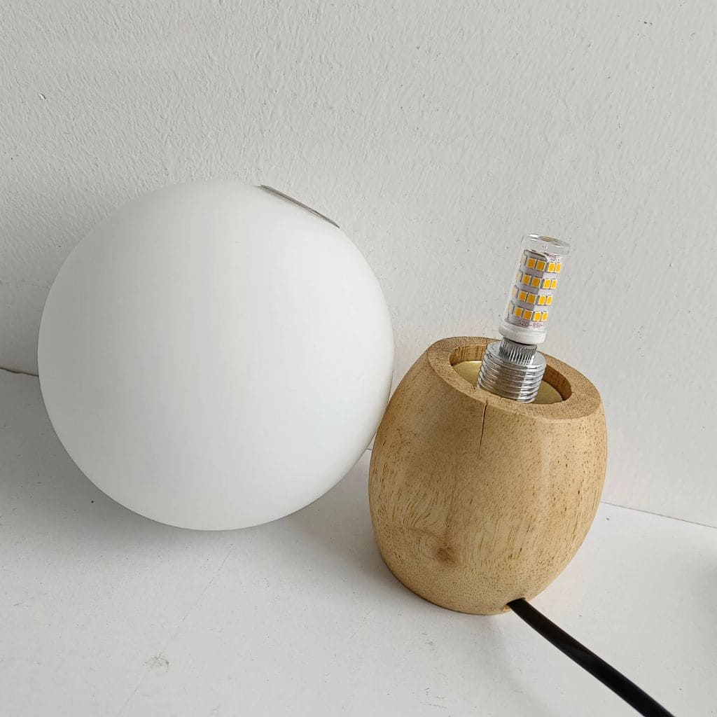 Lampada da tavolo in legno nordico con latte a sfera di vetro bianco